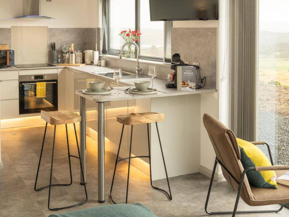 A kitchen with stools and a countertop at Migdale Heights - Luxury Cabins in The Highlands