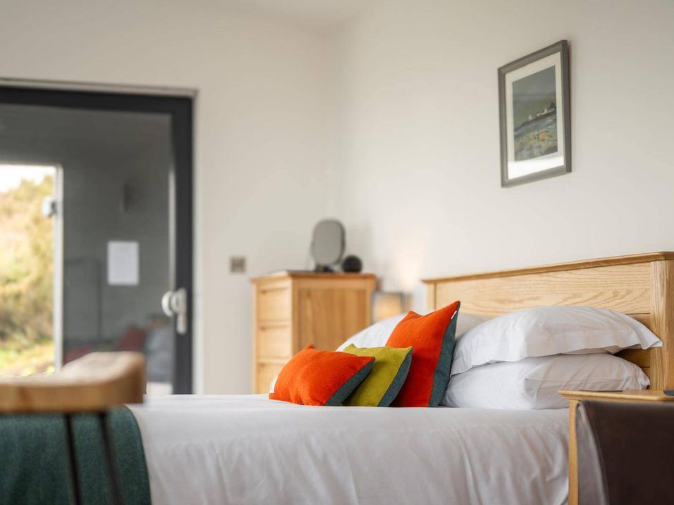 A bedroom with a bed and pillows at Migdale Heights - Luxury Cabins in The Highlands