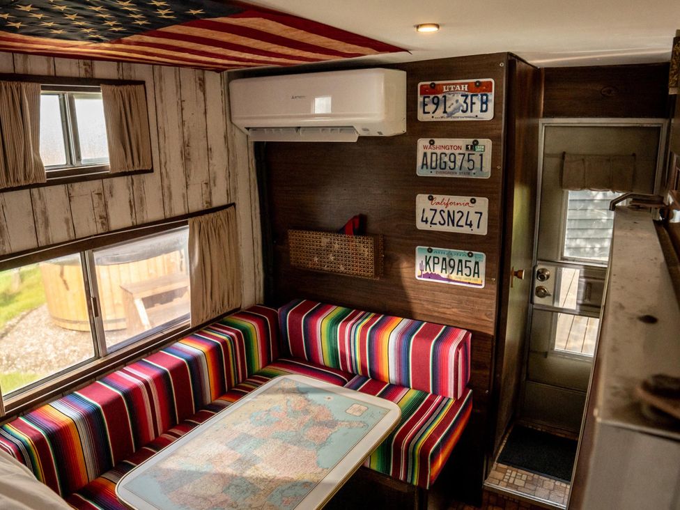 A living room with a colorful seat and table with a map at 1 Bed Vehicle Luxury Camper -Hot Tub, Pets - Willy, Mill Lane Farmhouse near Burgh Le Marsh