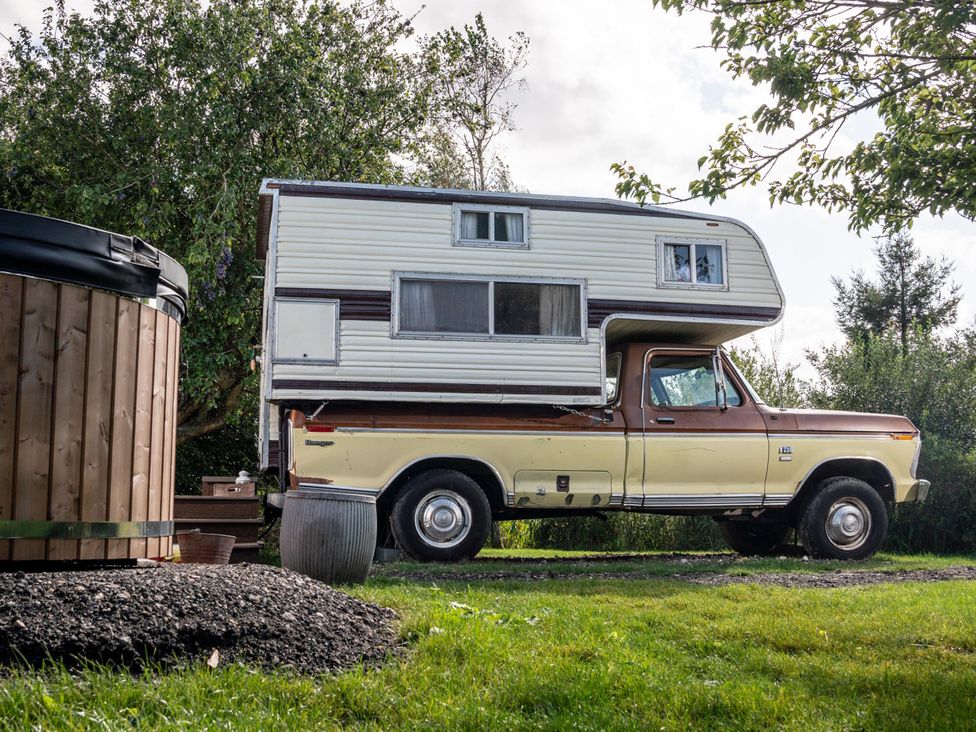 A camper parked next to a hot tub at 1 Bed Vehicle Luxury Camper -Hot Tub, Pets - Willy near Mill Lane Farmhouse near Burgh Le Marsh