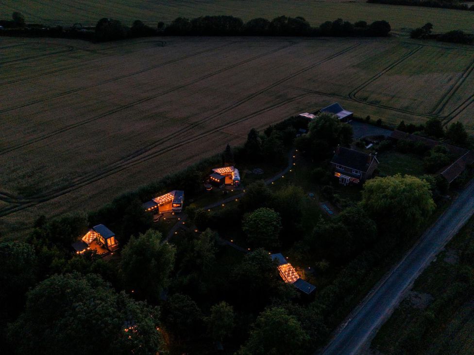 An aerial view of a property with illuminated units and surrounding fields at 1 Bed Vehicle Luxury Camper -Hot Tub, Pets - Willy, Mill Lane Farmhouse near Burgh Le Marsh