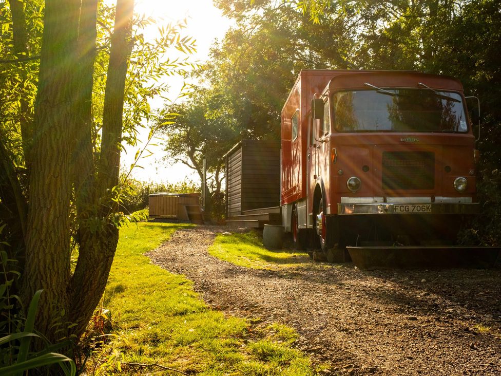 An outdoor scene with a truck and cabin by a hot tub at Sleeps 2 -Private Garden -Pets Ok -Hot Tub -Dennis