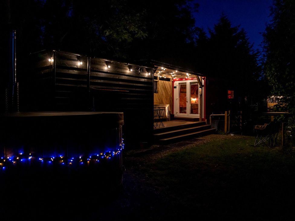 An outdoor space with a hot tub and lights at Sleeps 2 -Private Garden -Pets Ok -Hot Tub -Dennis