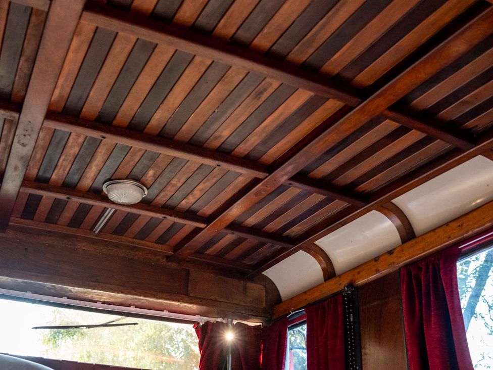 A ceiling with wooden beams and light fixture at Sleeps 2 -Private Garden -Pets Ok -Hot Tub -Dennis