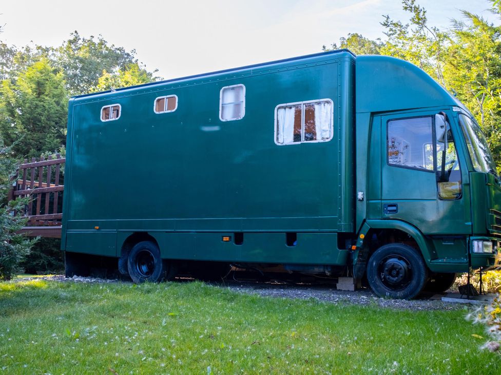A green truck parked on grass with a wooden deck at 1 Bed -Private Garden -Hot Tub -Pets Ok - Gee Gee