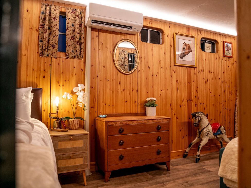 A bedroom with a bed, dresser, and decorative items at 1 Bed -Private Garden -Hot Tub -Pets Ok - Gee Gee