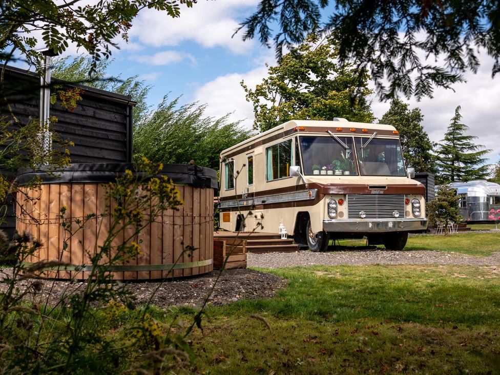 An outdoor area with a retro RV and a hot tub at Sleeps 2 -Pets Welcome -Private Hot Tub -Alabama