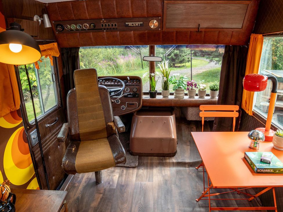 A living area with a steering wheel and table at Sleeps 2 -Pets Welcome -Private Hot Tub -Alabama