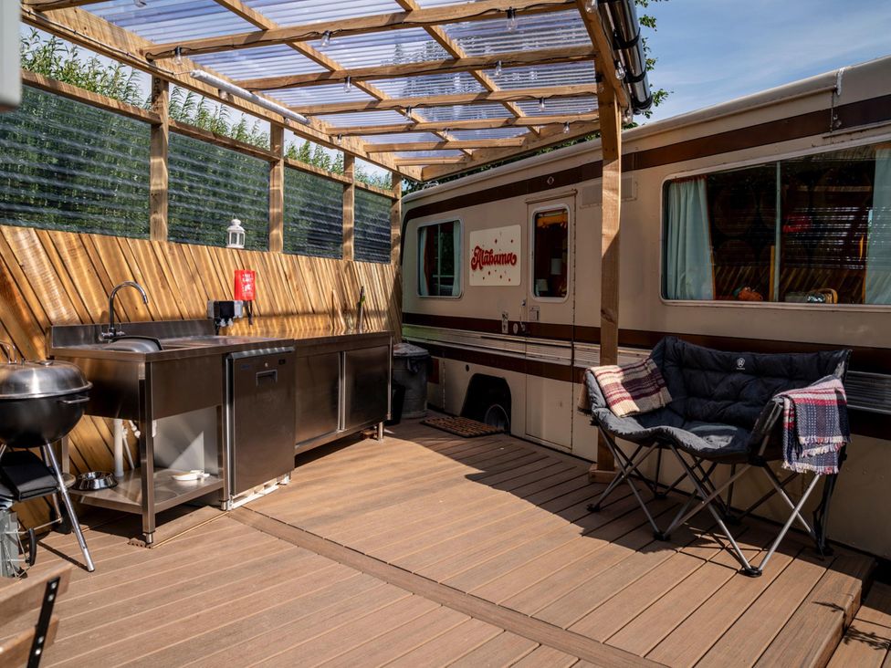 An outdoor kitchen with a sink and chair at Sleeps 2 -Pets Welcome -Private Hot Tub -Alabama