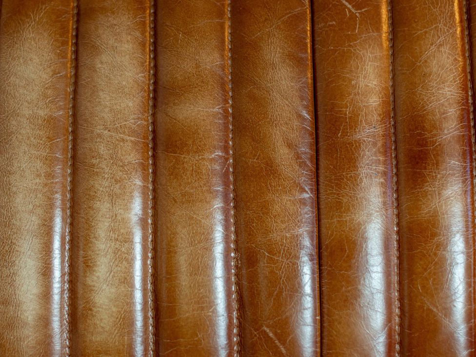 A close-up of leather paneling with stitching