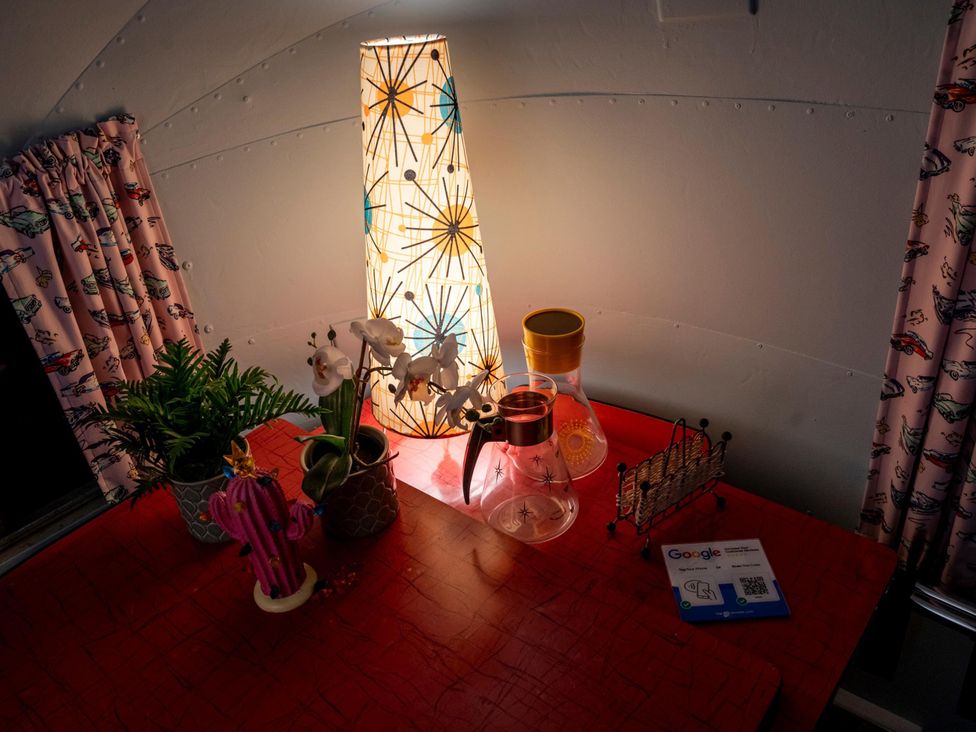 A dining area with a lamp, plants, and decorative items at Sleeps 2 - Hot Tub - Pet Friendly - PeggySue