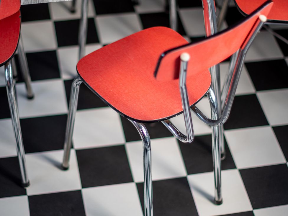 A dining room with red chairs and a black and white checkered floor at Sleeps 2 - Hot Tub - Pet Friendly - PeggySue