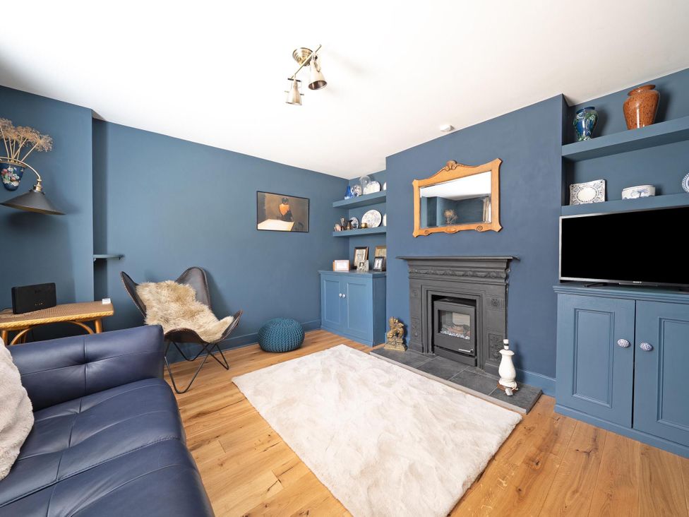 A living room with a fireplace and shelves at 3 Bed House - Sleeps 5 - Garden - Pets - Parking