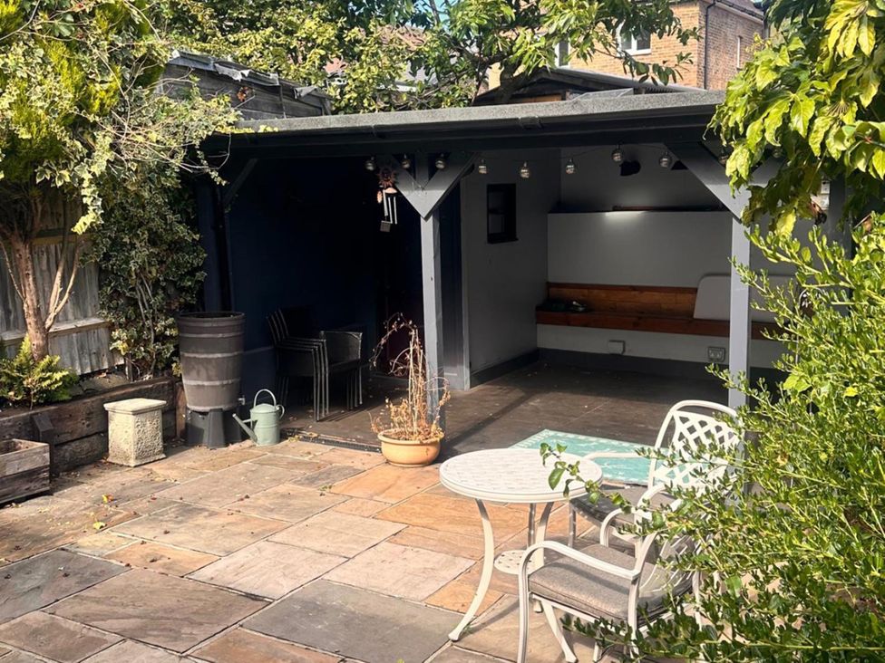 An outdoor garden area with a table and chairs at 3 Bed House - Sleeps 5 - Garden - Pets - Parking
