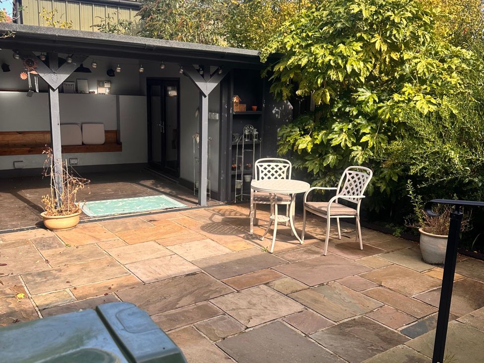 A garden with a table and chairs and a shelter at 3 Bed House - Sleeps 5 - Garden - Pets - Parking