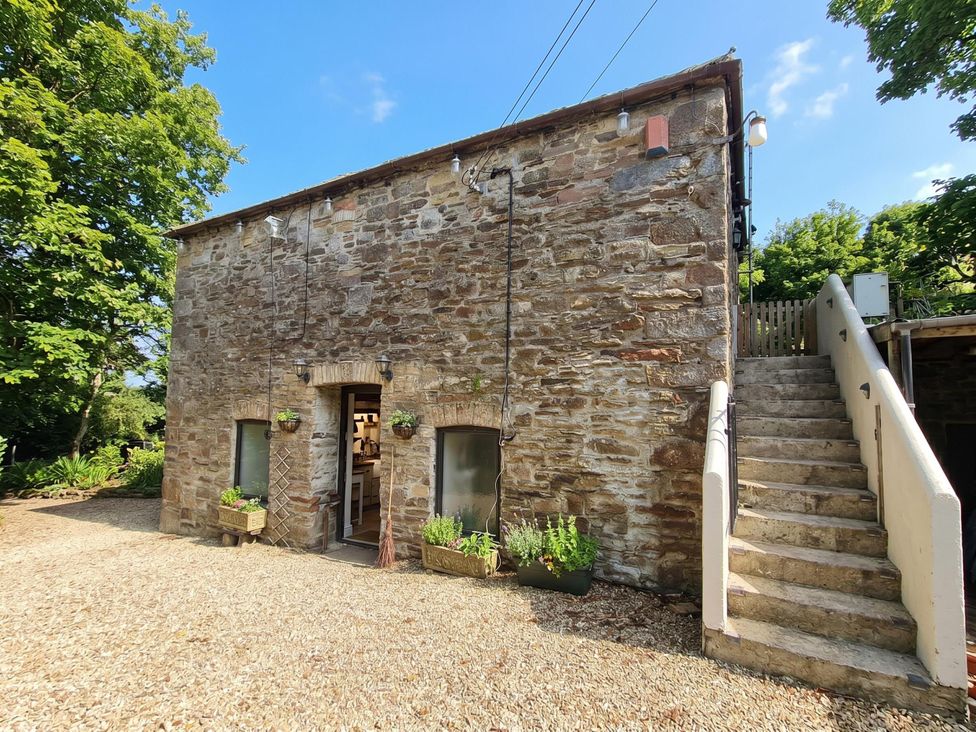 A stone building with steps and planters at a property