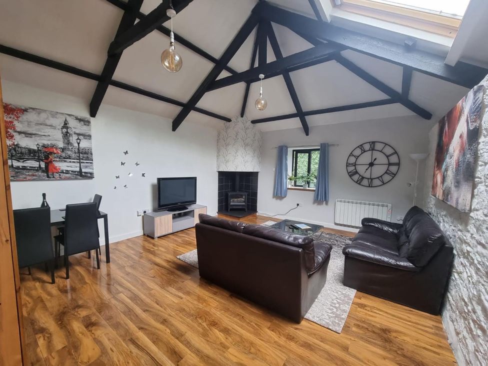 A living room with a sofa, chairs, table, and television at the property
