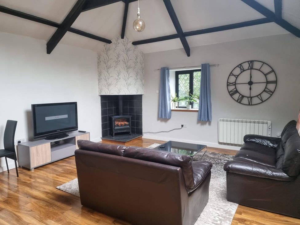 A living room with a sofa, coffee table, and TV at the property