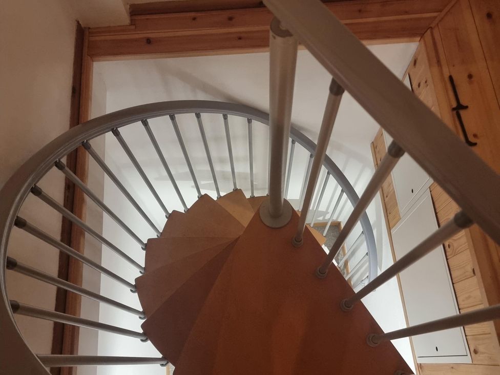 A spiral staircase with wooden steps and metal railings