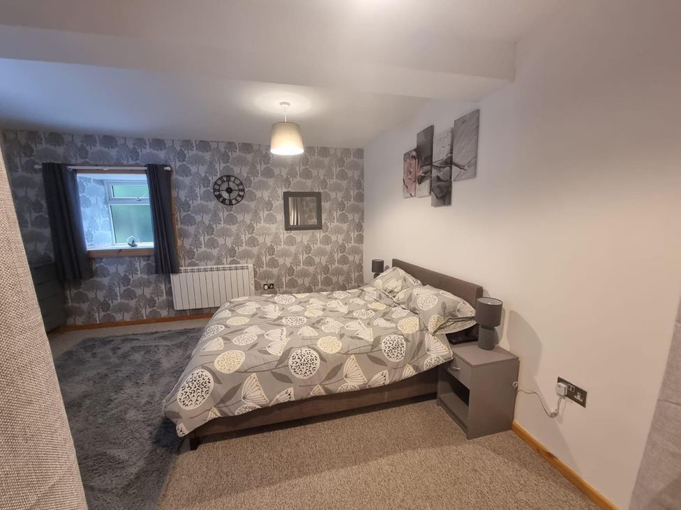 A bedroom with a bed and bedside table at The Old Barn in Manchester