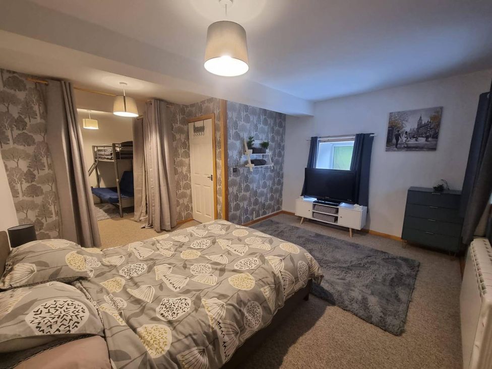 A bedroom with a bed, television, and bunk bed at The Old Barn in Manchester