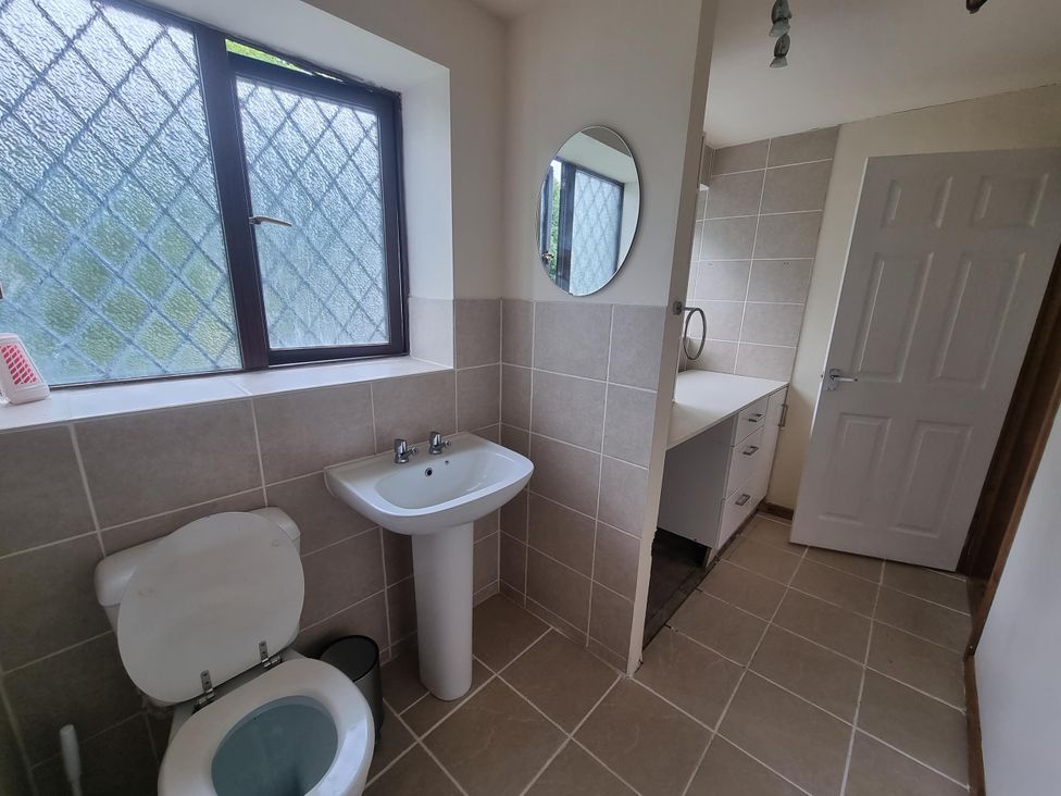 A bathroom with a toilet, sink, and mirror at the property in location