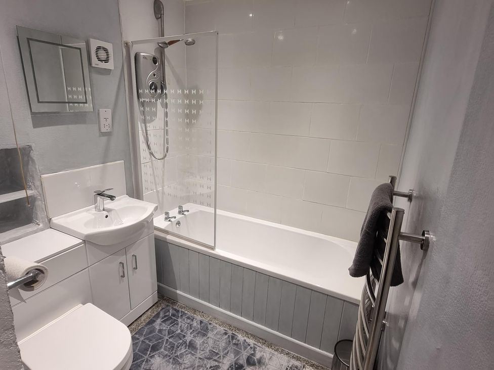 A bathroom with bathtub, shower, sink, and toilet at The Old Barn in Manchester