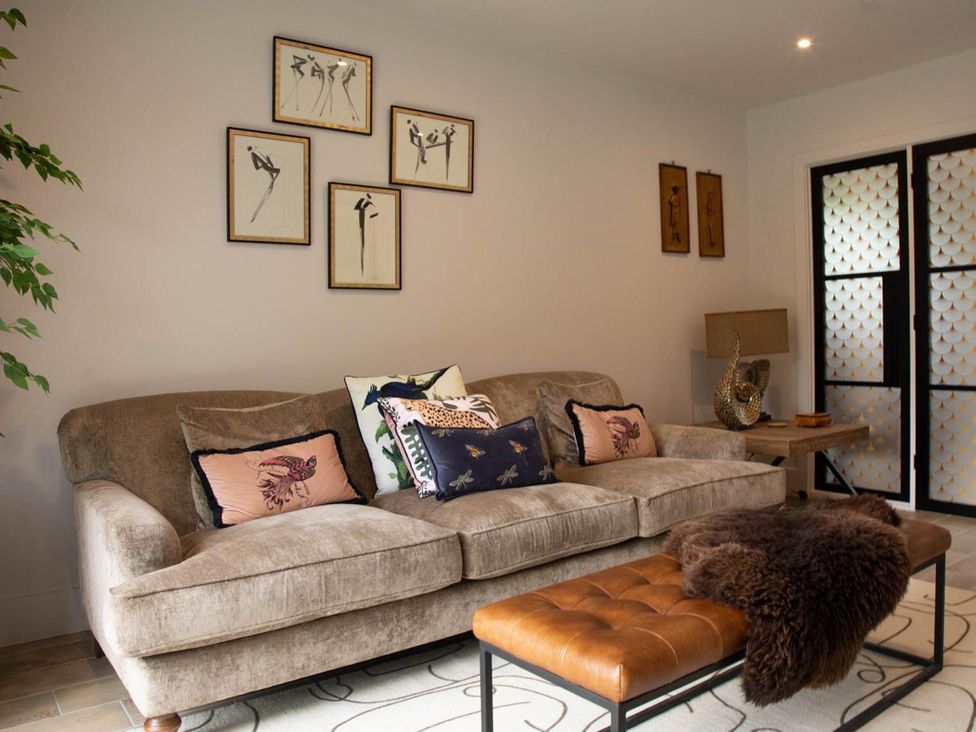 A living room with a sofa and art prints at House Sleeps 10 with Enclosed Garden