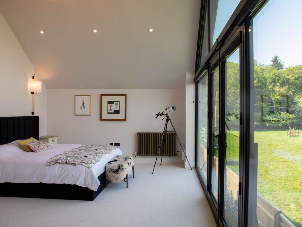 A bedroom with a bed and telescope at House Sleeps 10 with Enclosed Garden