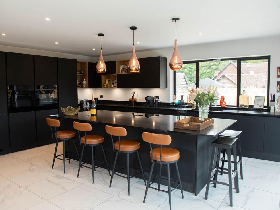 A kitchen with an island and bar stools at House Sleeps 10 with Enclosed Garden