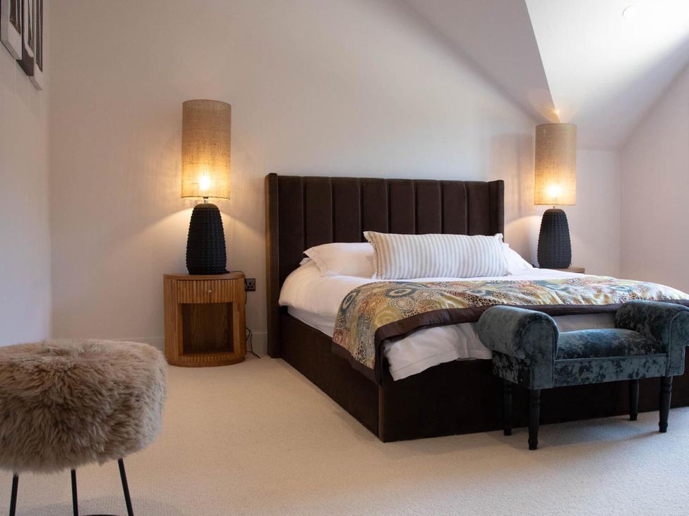 A bedroom with a bed, bedside table, and lamps at House Sleeps 10 with Enclosed Garden