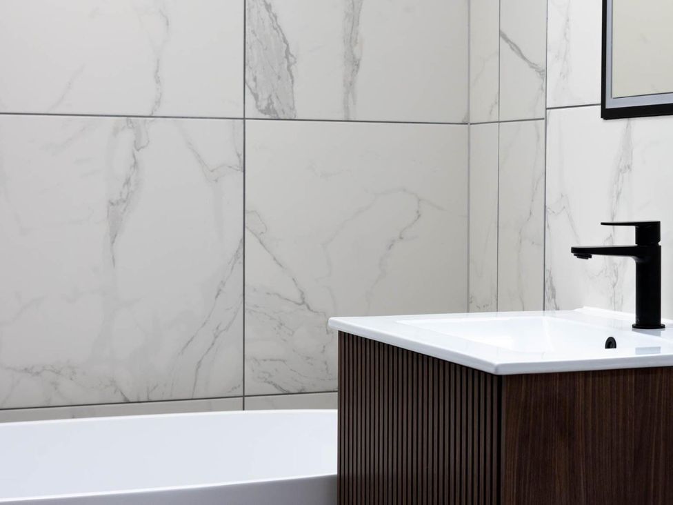 A bathroom featuring a bathtub and sink at House Sleeps 10 with Enclosed Garden