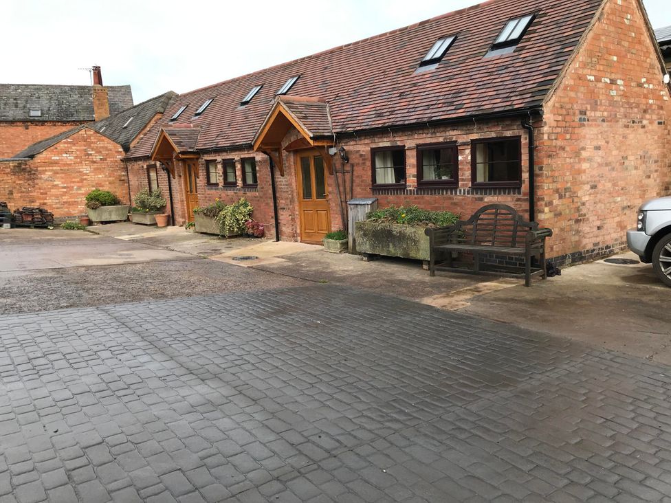 An outdoor area with a brick building and a bench at the property