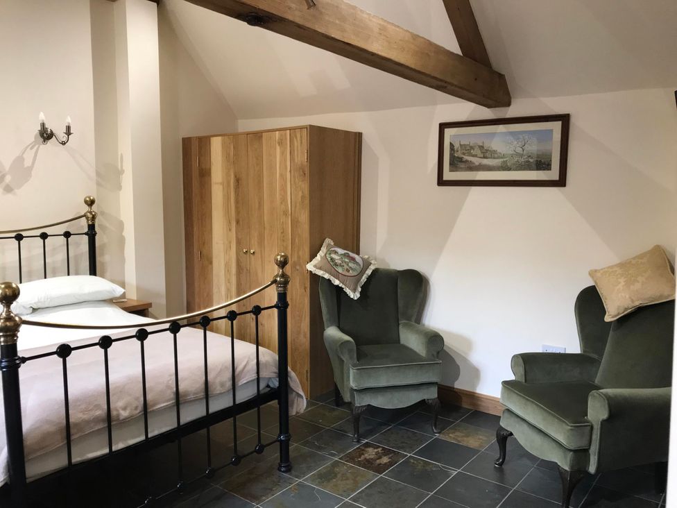 A bedroom with a bed and two armchairs at the property in location