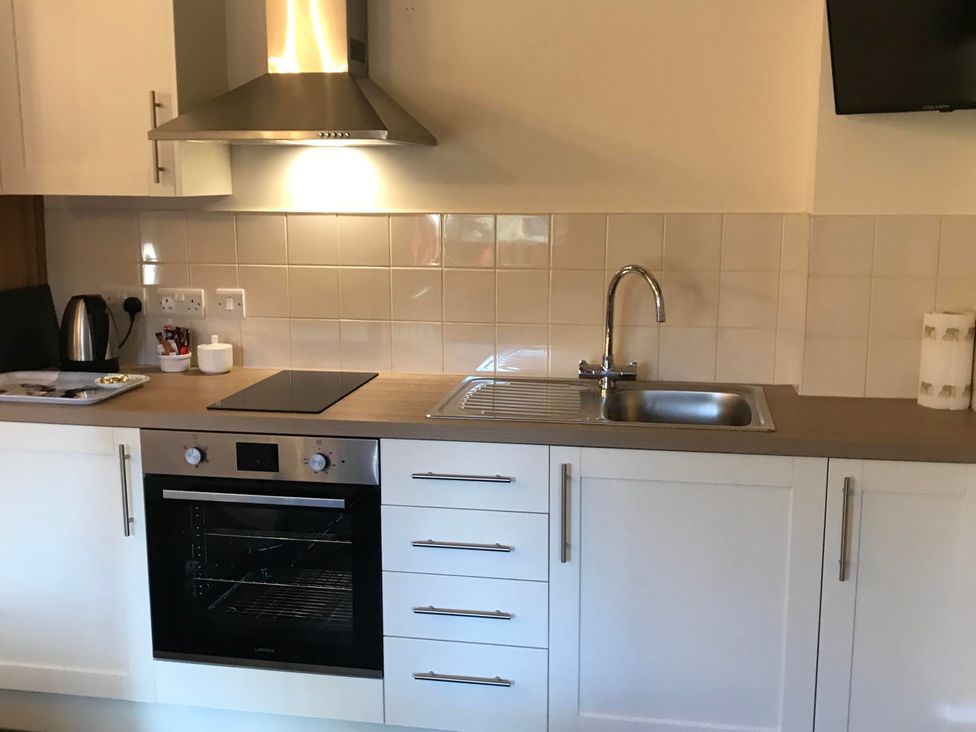 A kitchen with a sink, stove, oven, and kettle at the property