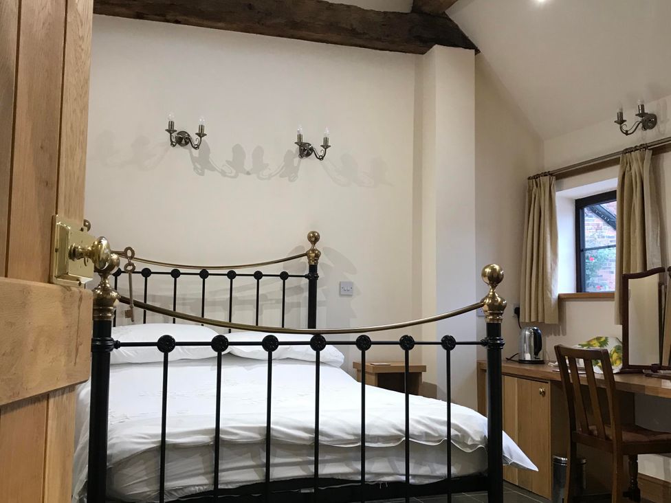 A bedroom with a bed and a table at The Old Barn in Manchester