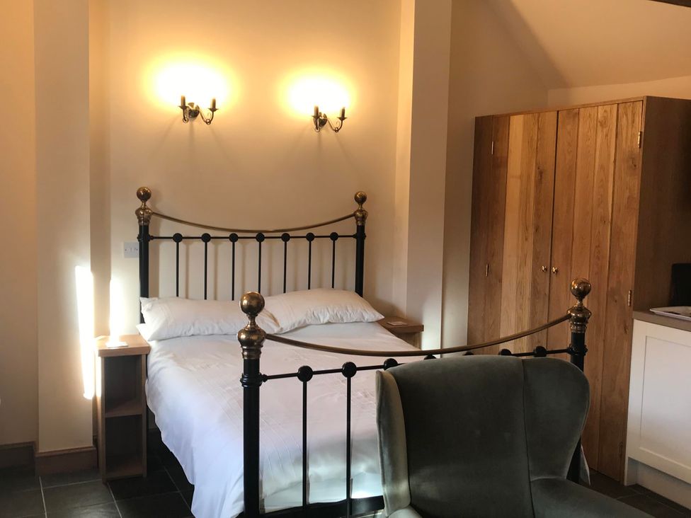 A bedroom with a bed and wardrobe at The Old Barn in Manchester