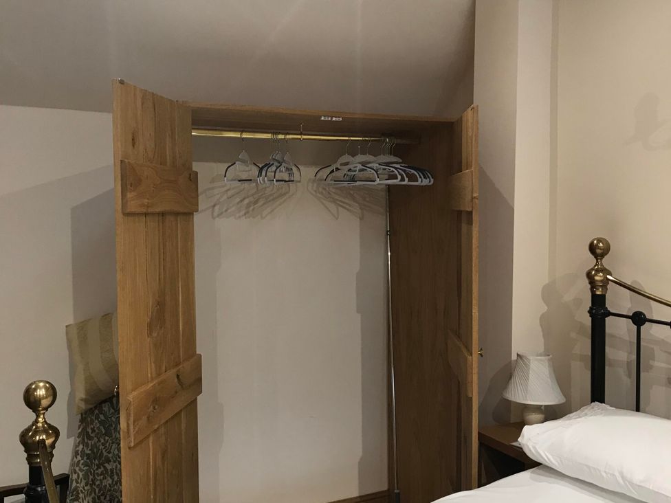 A wardrobe with hangers in a bedroom at The Old Barn in Manchester