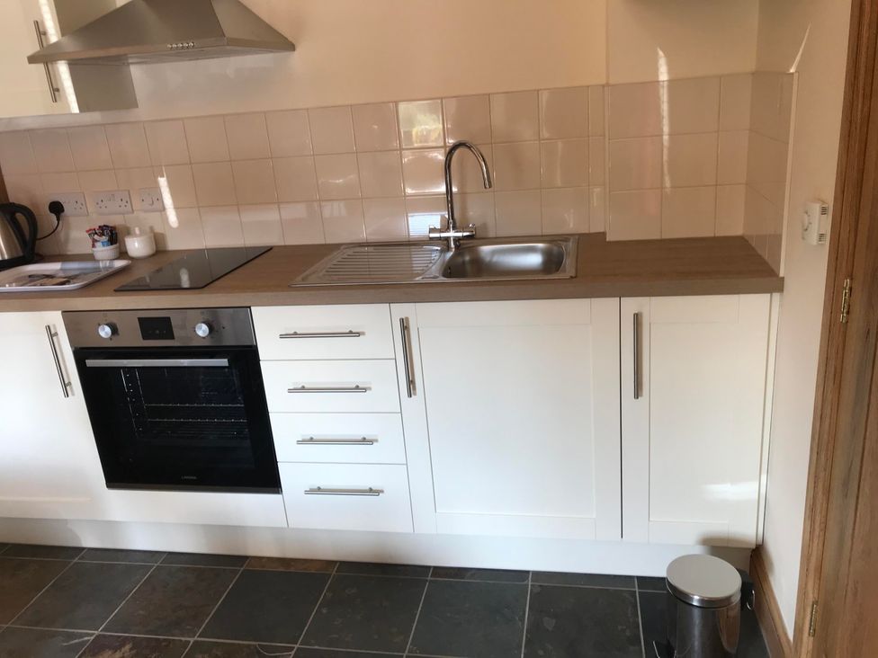 A kitchen with a sink and oven at The Old Barn in Manchester