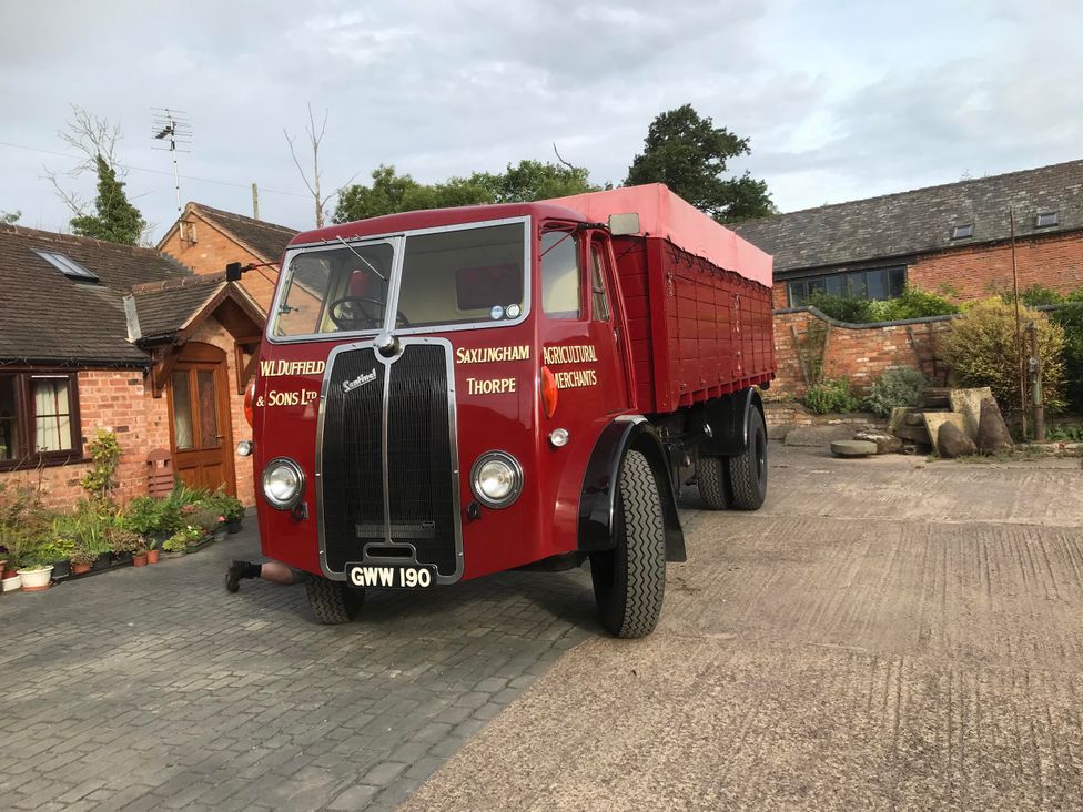 A red truck parked near buildings at an outdoor location