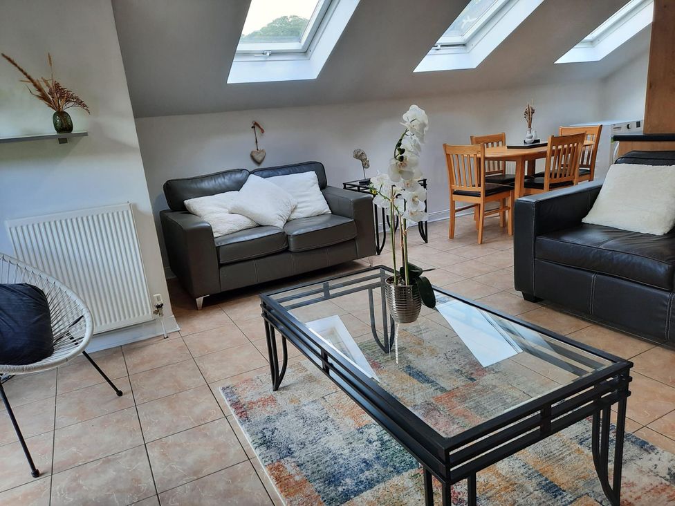 A living room with a sofa and dining table at The Old Barn in Manchester