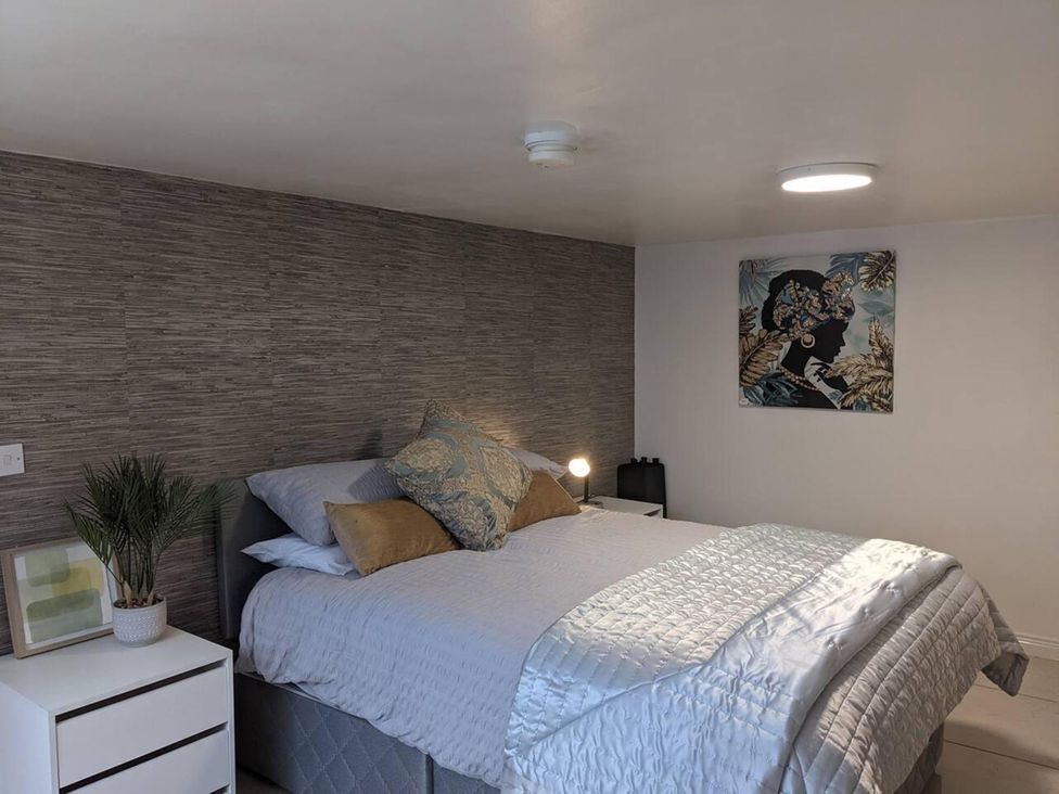 A bedroom with a bed and nightstand at The Old Barn in Manchester