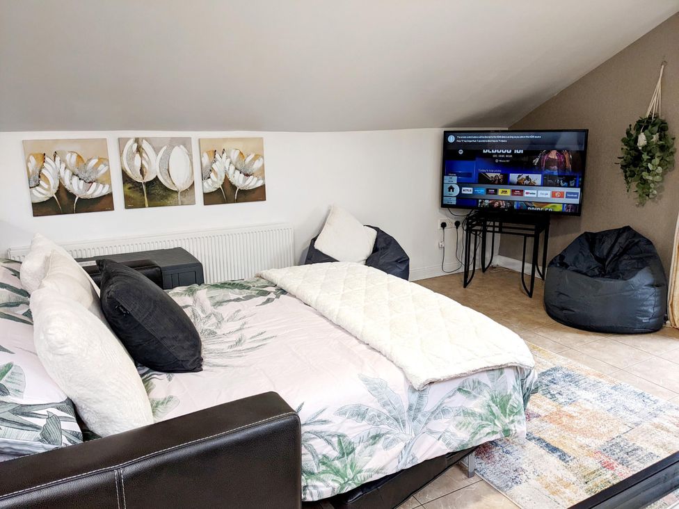 A bedroom with a bed and television at The Old Barn in Manchester