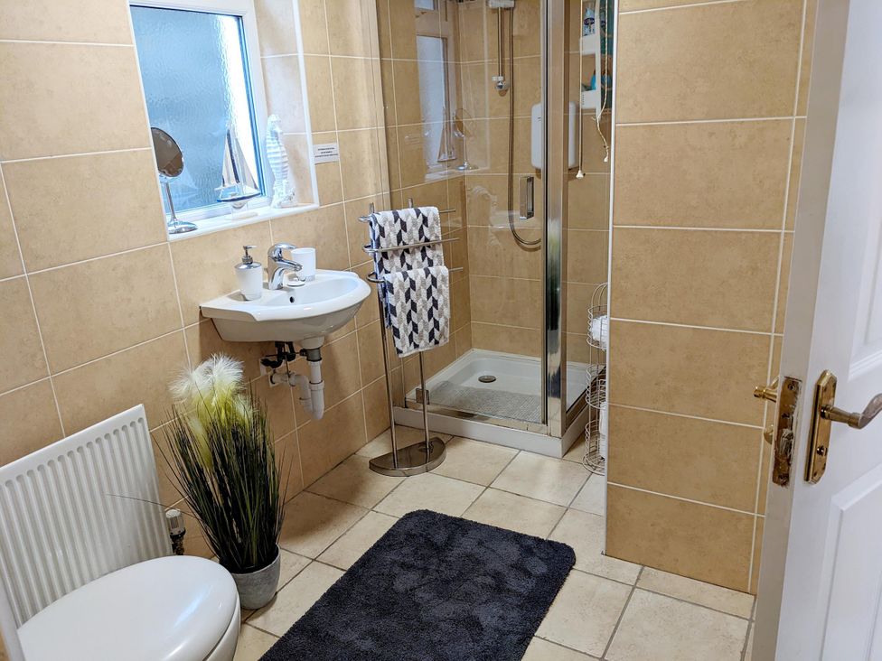 A bathroom with a sink, shower, and towel rack at The Old Barn in Manchester