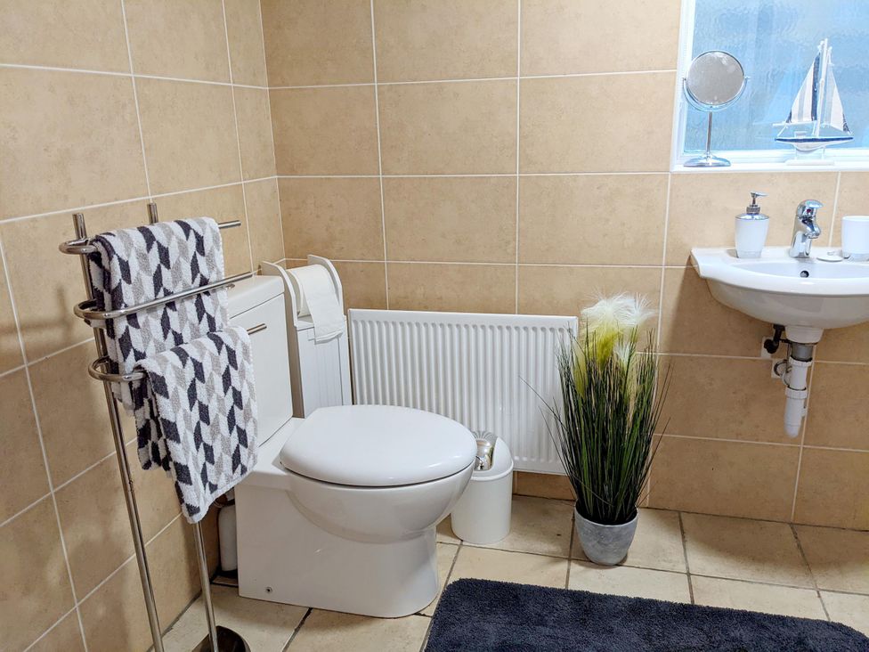 A bathroom with a toilet, sink, and towel rack at The Old Barn in Manchester