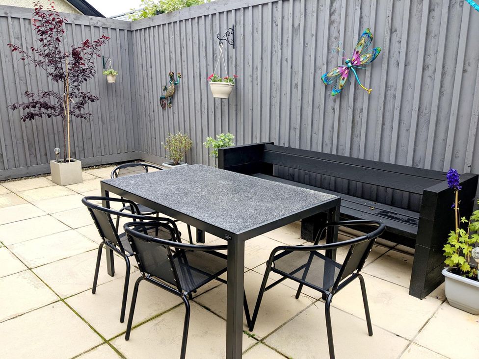 A garden with a table and chairs surrounded by plants at 