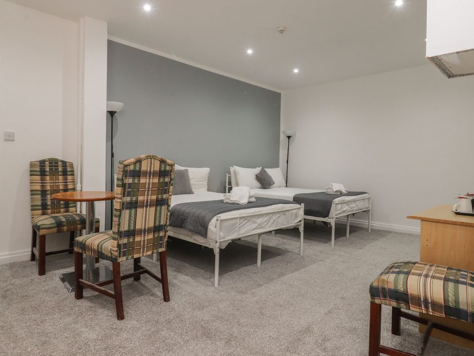 A bedroom with two beds and a dining table at Luxury Winter Gardens Apartment 1 Blackpool