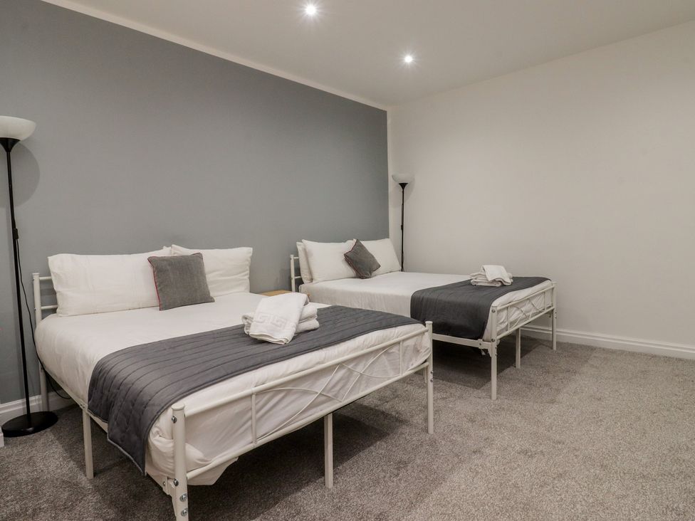 A bedroom with two beds and a lamp at Luxury Winter Gardens Apartment 1 Blackpool
