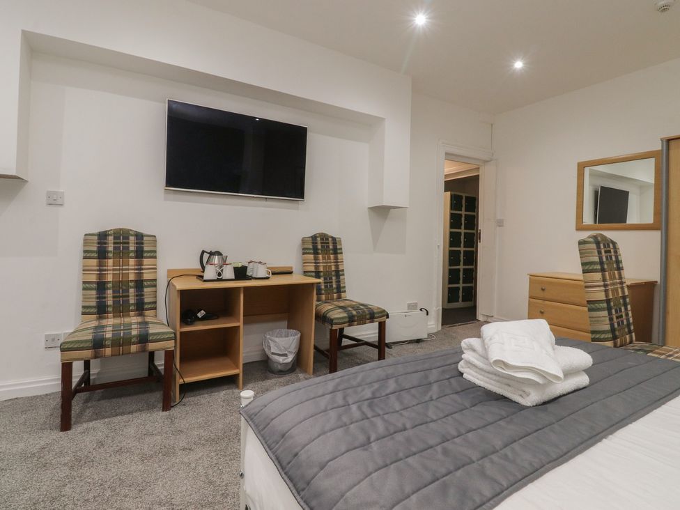 A bedroom with a table and television at Luxury Winter Gardens Apartment 1 in Blackpool