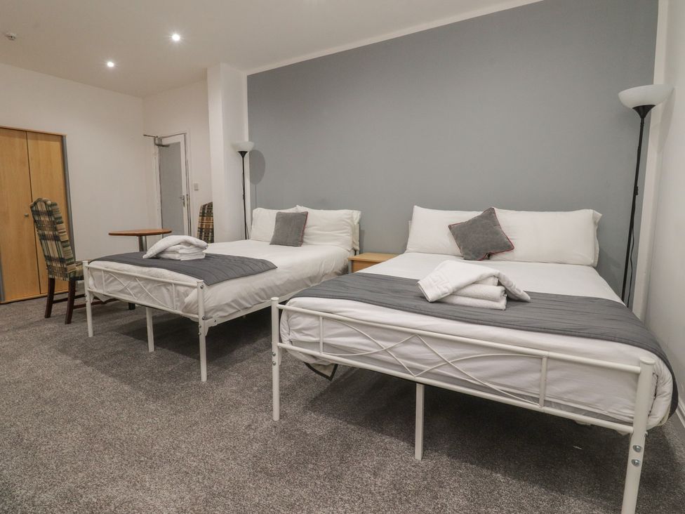 A bedroom with two beds and a nightstand at Luxury Winter Gardens Apartment 1 in Blackpool